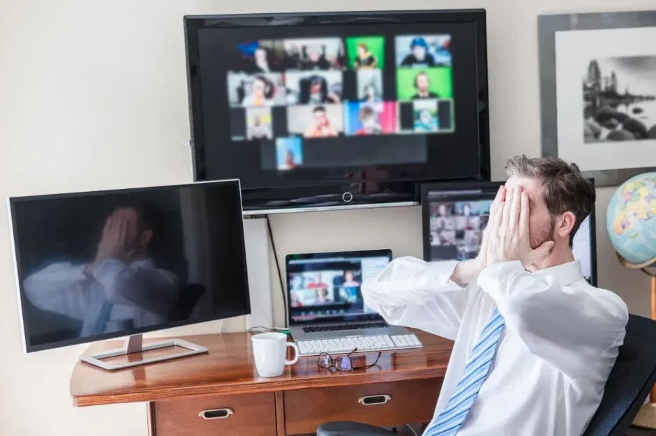 Man at office desk experiencing Zoom fatigue