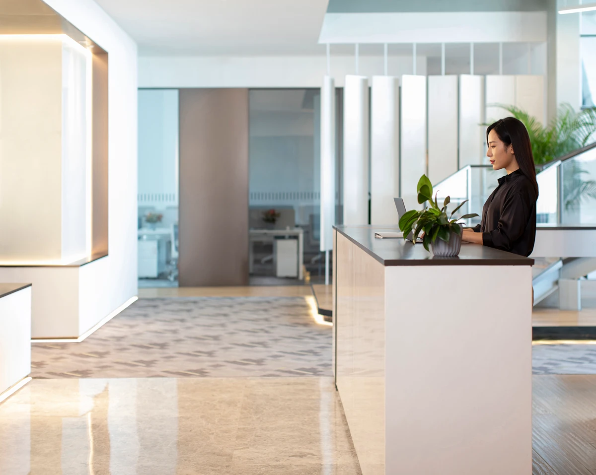 An office receptionist at a counter - a key inclusion in serviced offices